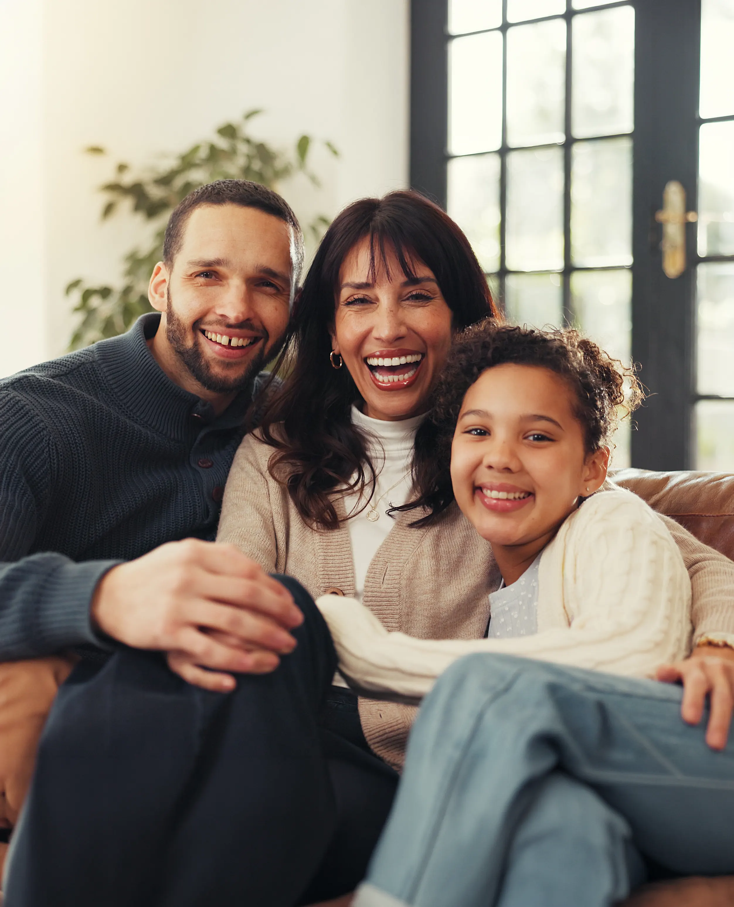 A smiling father, mother, and daughter together at home